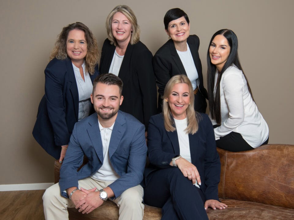 Gruppe von sechs lächelnden Menschen in Business-Kleidung.