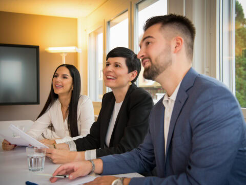 Drei Personen bei einem Meeting.