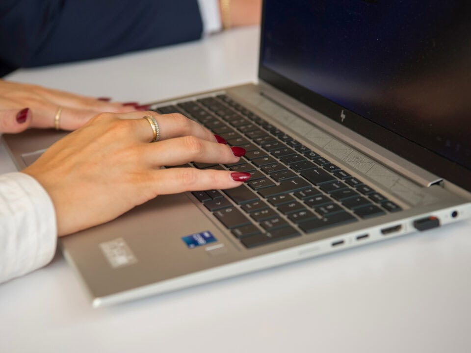 Hände tippen auf Laptop-Tastatur