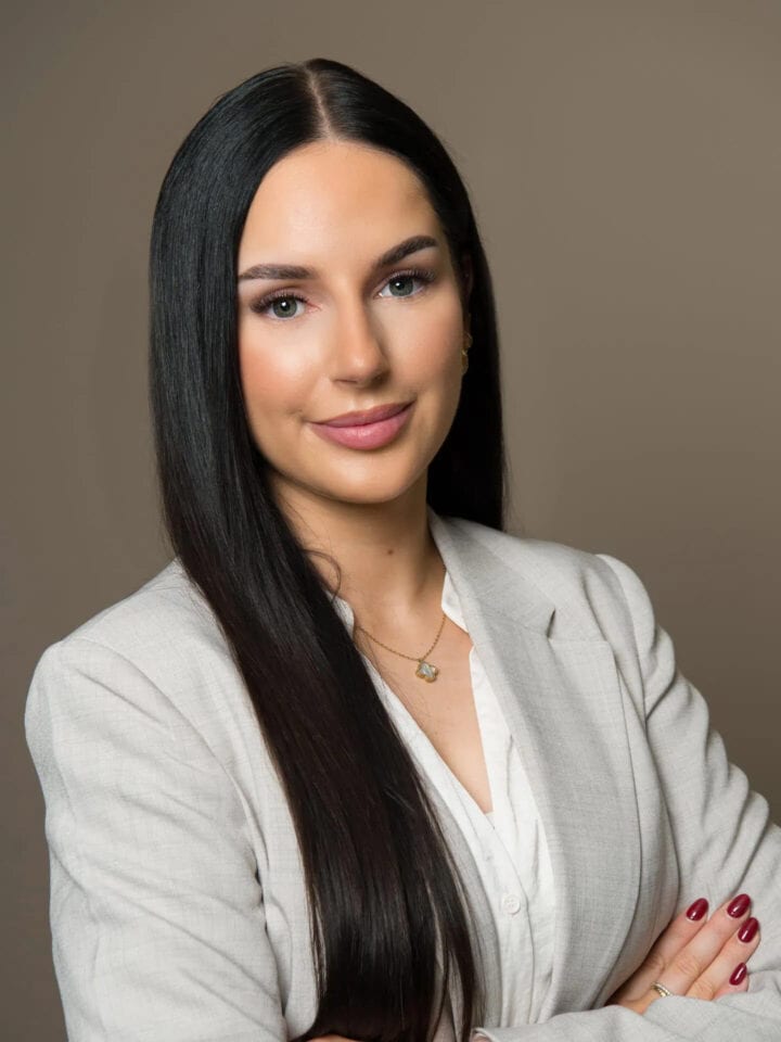 Frau in wei&szlig;em Blazer, lange dunkle Haare.